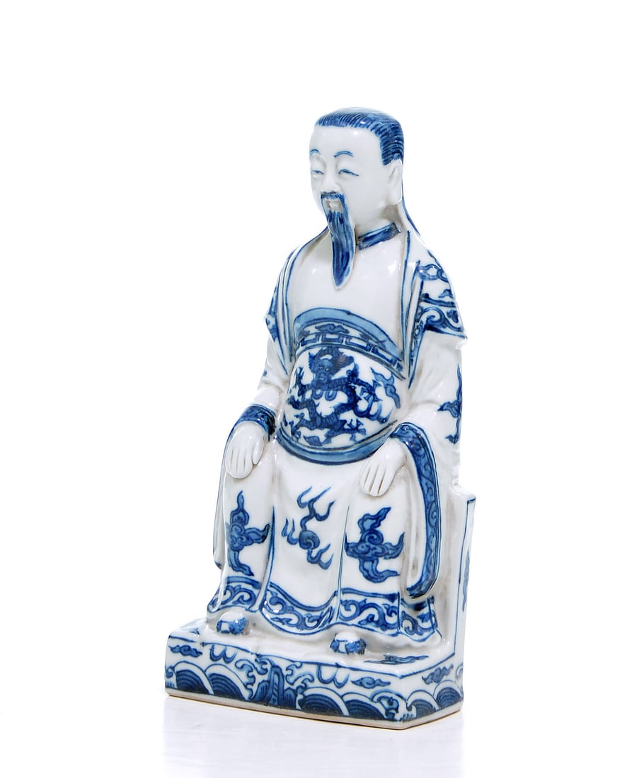 Rare Chinese Blue and White Statue of Taoist Deity: Porcelain figure of seated Zhenwu, masterfully rendered in a vibrant underglaze cobalt blue against a luminous white ground. The figure is depicted in a formal seated posture, wearing voluminous robes