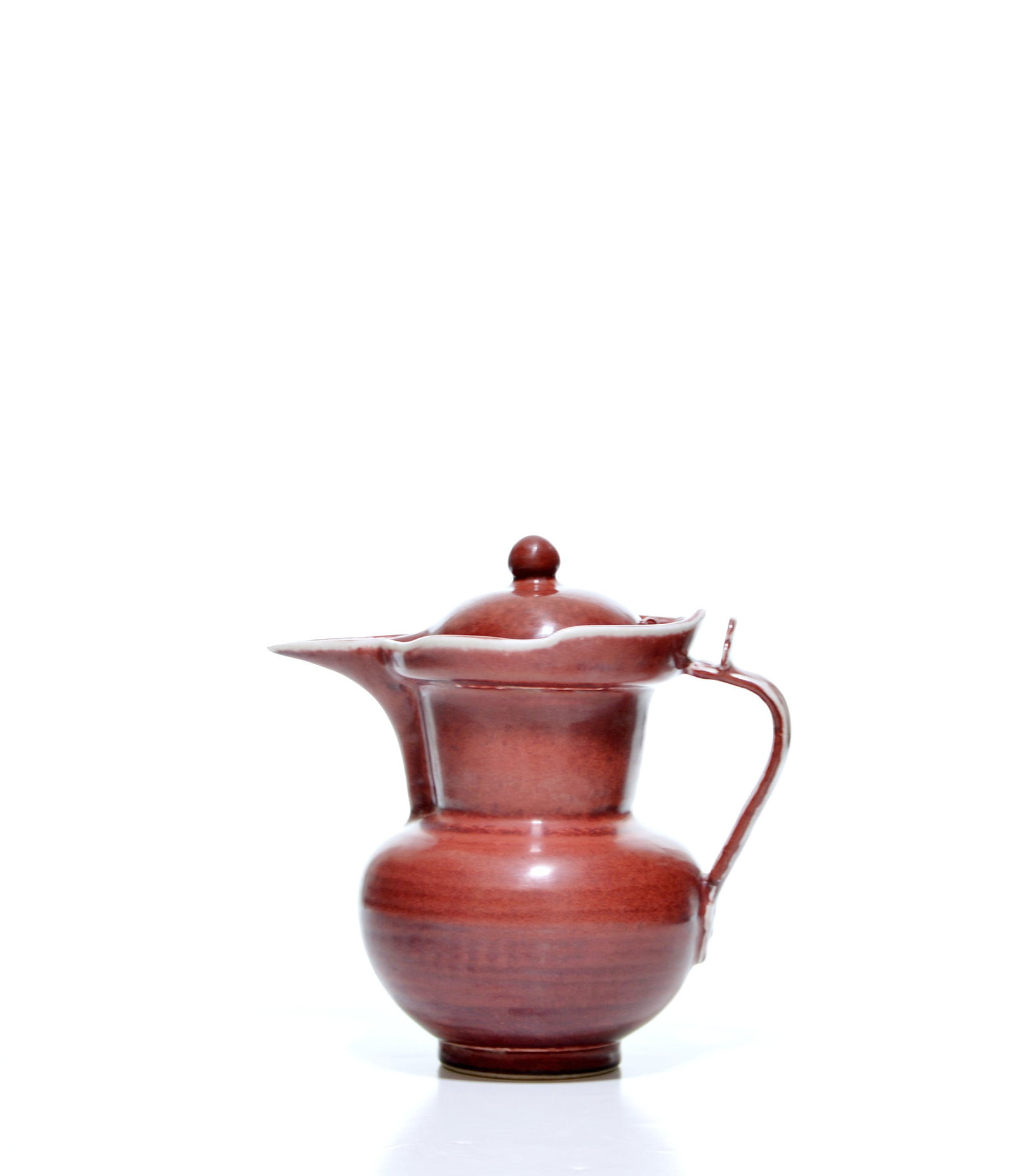 Rare Chinese Copper-Red 'Monk-Cap' Vase: The globular body rises from a recessed foot through a tapering neck to a broad, undulating rim, fitted with a domed cover surmounted by a spherical finial. It is applied with a pointed spout and a