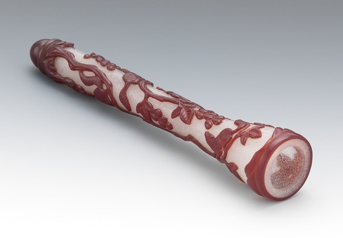 Chinese Ruby-Overlay Glass Brush Handle: Of elongated cylindrical form, carved through a deep ruby-red overlay to a pale pink translucent ground. The body is decorated in high relief with squirrels on tree branches. H: 18 cm , 7 in