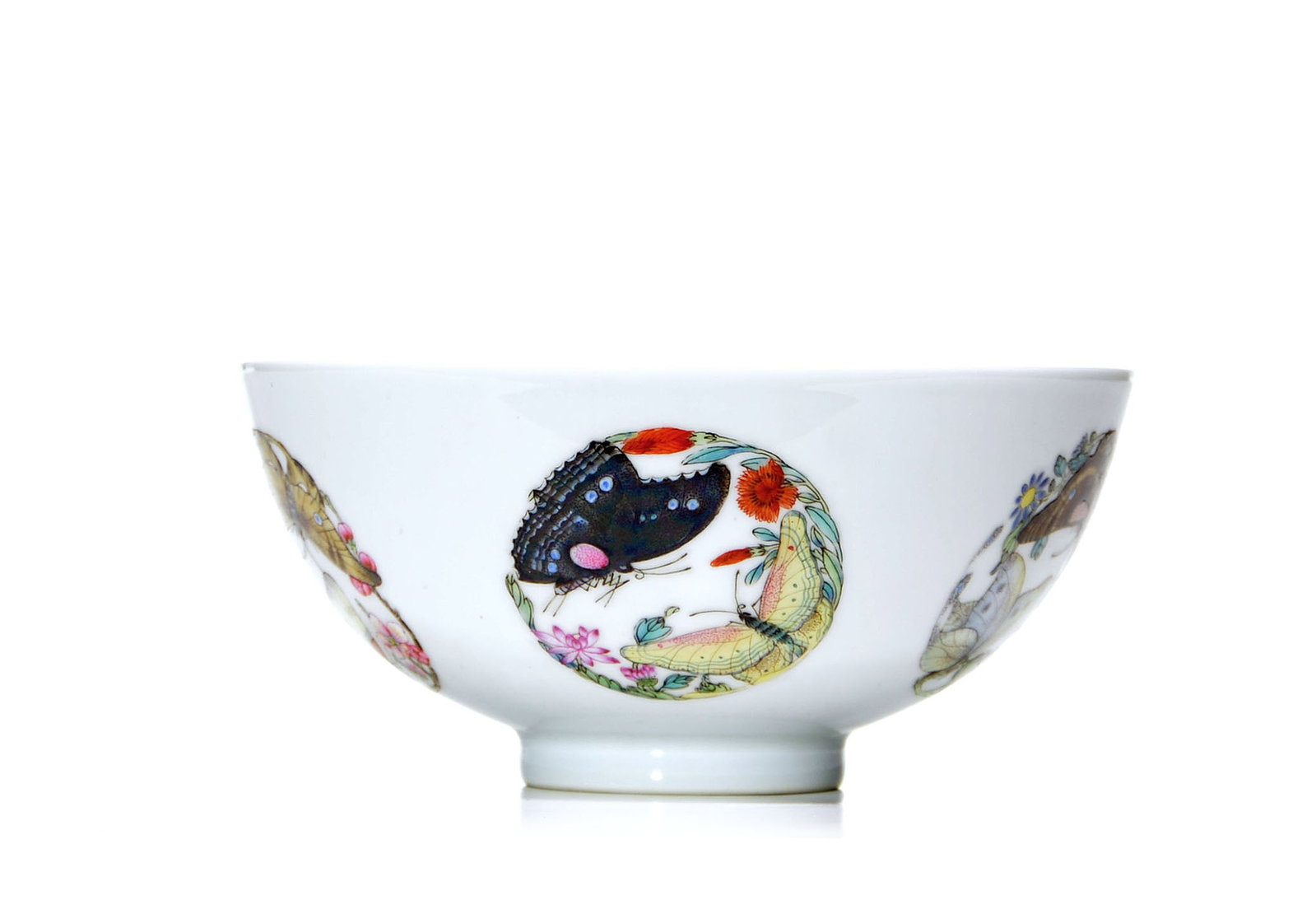 Chinese Famille Rose Butterfly Bowl: The bowl is finely potted with gently flaring sides rising from a short foot, and is covered overall in a clear glaze. The exterior is decorated in famille rose enamels with alternating roundels of