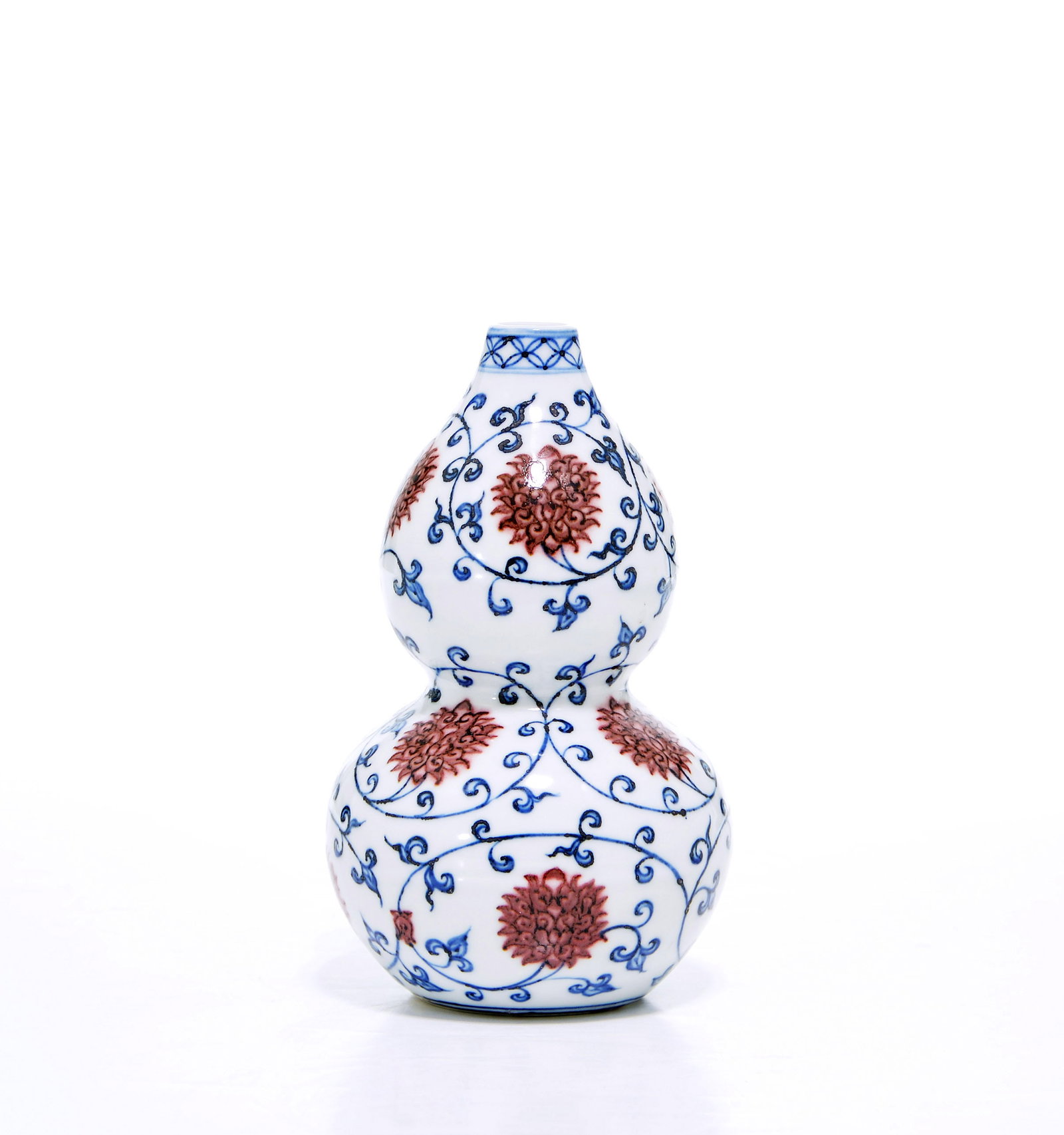 Rare Chinese Yuan-Style Double-Gourd Vase: Double-gourd vase of balanced form, delicately painted in underglaze blue and copper red with scrolling floral blossoms. The lower bulb is encircled by large blooms amidst fine scrolling foliage, mirr
