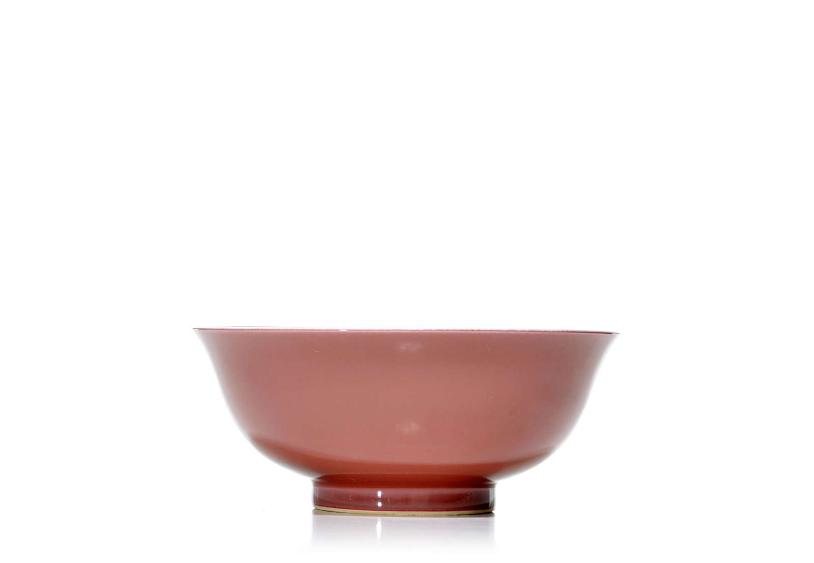 Rare Chinese Copper-Red Bowl: The bowl is finely potted with rounded sides rising from a short, slightly recessed foot to a gently flared rim. The exterior is covered in a rich copper-red glaze, the underside reserved in white