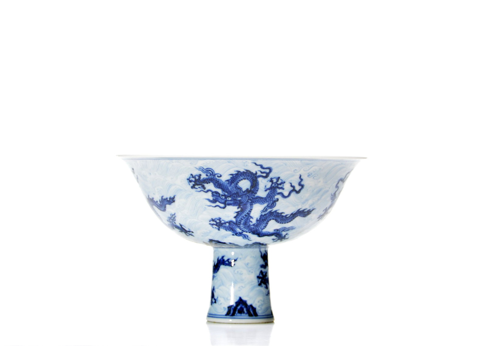 Chinese Blue and White Dragon Stem Bowl: The flared bowl is raised on a slightly splayed cylindrical stem and covered overall in a transparent glaze. It is painted in cobalt blue with pairs of writhing dragons amid waves and cloud scrolls,