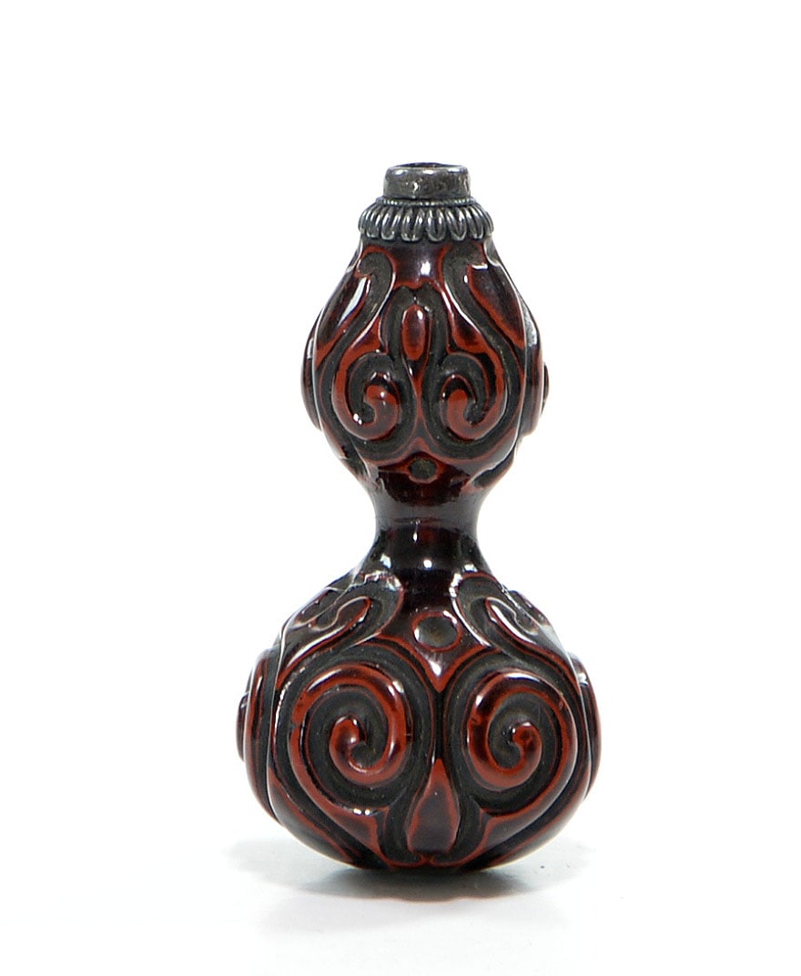 Very Rare Chinese Song-Ming 'Tixi' Gourd Vase: The lacquer double-gourd vase is moulded in high relief with scrolling foliate motifs, rendered in deep blackish-brown and russet tones. It has a short cylindrical mouth above a collar of overlapping