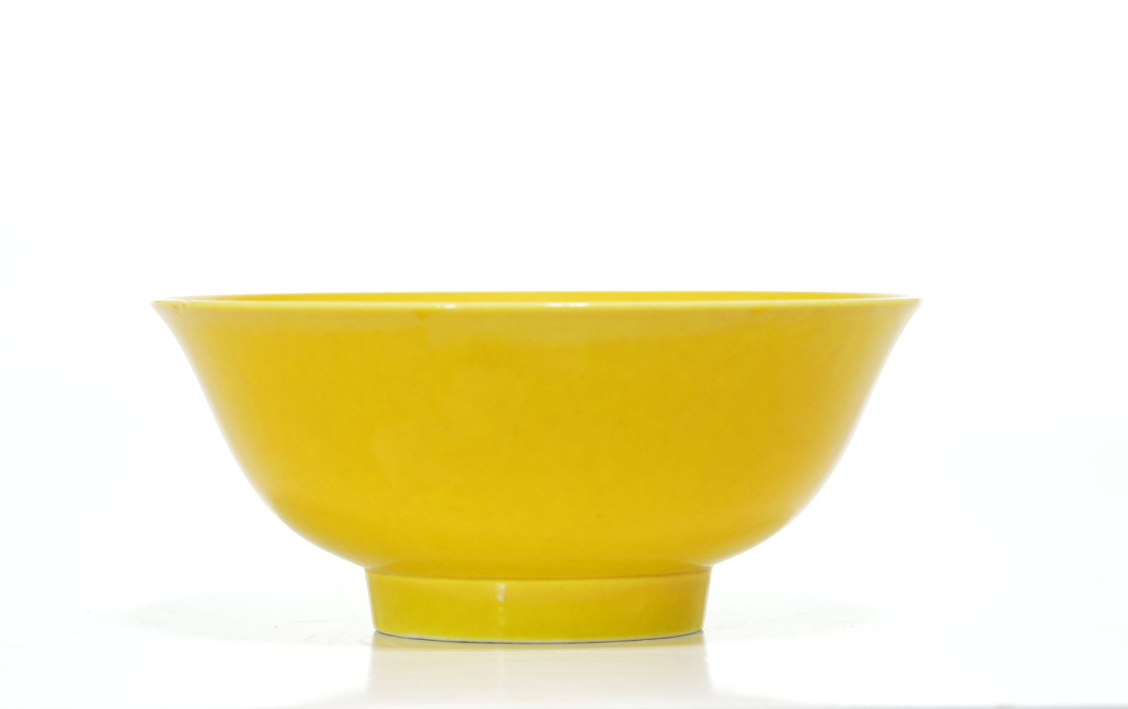 Very Fine Chinese Imperial Yellow Bowl: The deep rounded bowl is raised on a short, straight foot and finished with a gently flared rim. It is covered overall in a rich yellow glaze, the recessed base glazed white and inscribed in