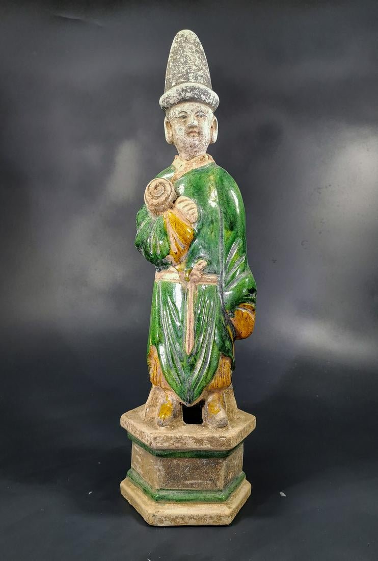 Chinese Ming Dynasty Attendant Figurine: Ca. 1368-1644 AD. Attractive green glazed terracotta figurine. Male attendant figurine, with draped glazed green robes, holding towel, standing on a lotus flower.Good condition, original glazing; Size