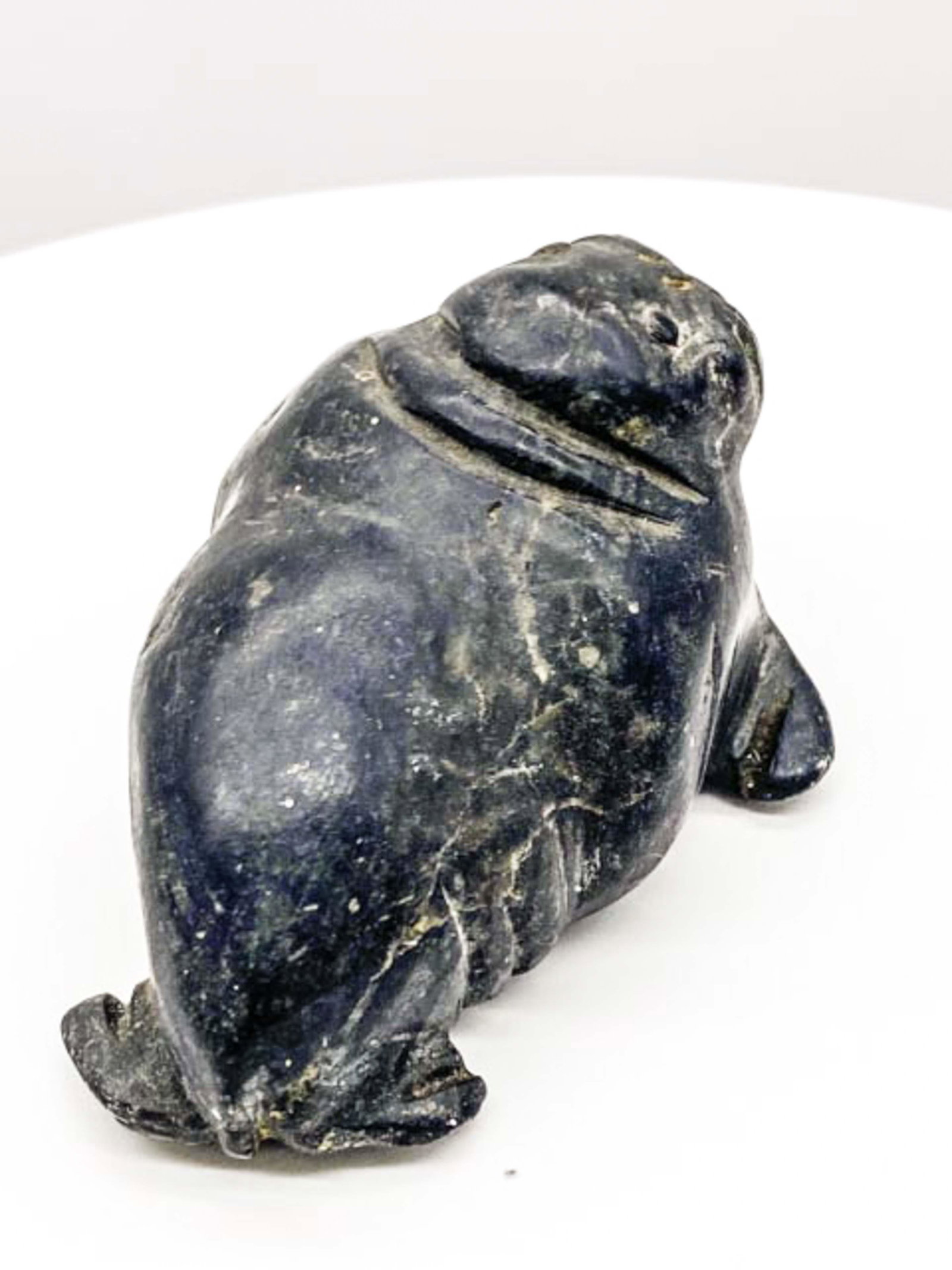 Inuit Carved Obsidian Statue Of Walrus By Noted Artist: Hand carved statue of a walrus. Made of obsidian with added organic tusks. Beautiful craftsmanship. Good condition.