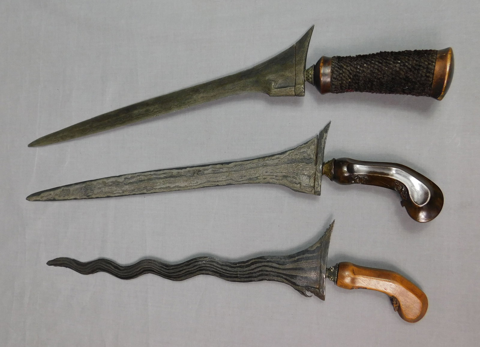 3 Kris. Ohne Scheide. Alt.: 3 Teile. Stammeskunst. Zustand und Maße siehe Fotos. Versand kann organisiert werden. Kris. Without scabbard. Old. 3 parts. Tribal art. See photos for condition and measurements. Shipping can be orga