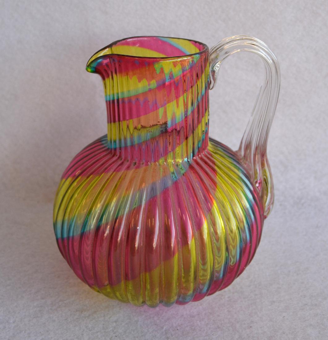 Art glass pitcher with applied handle ribbed rainbow: Art glass pitcher with applied handle ribbed rainbow design and hand blown - 19th century - 6"H. SORRY - JUST NOTICED A HEAT CHECK AT BASE OF HANDLE, no other issues.