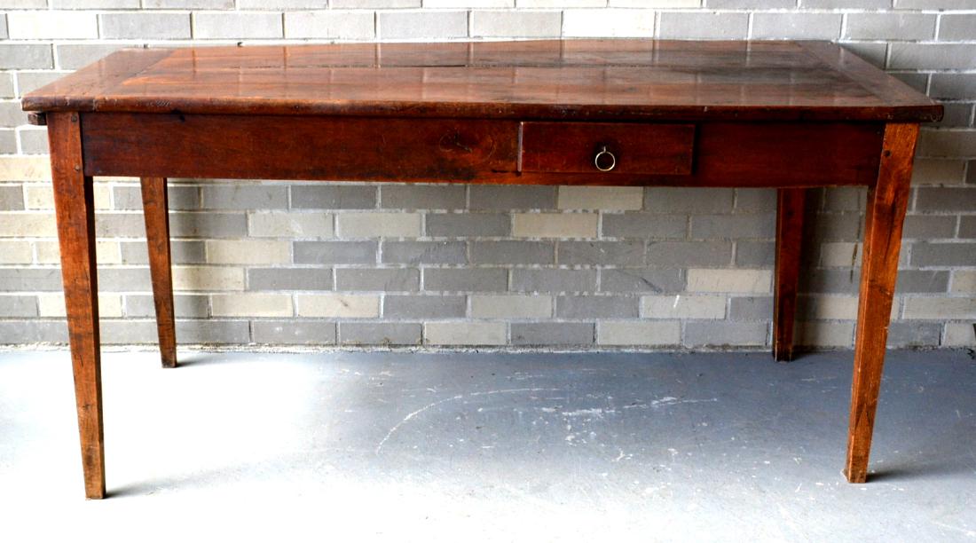 A country French farm table with taper legs and single: A country French farm table with taper legs and single drawer – top with bread board ends – one end also with pullout serving tray. Reportedly from Pierre Deux, French decorator/importer. Top with