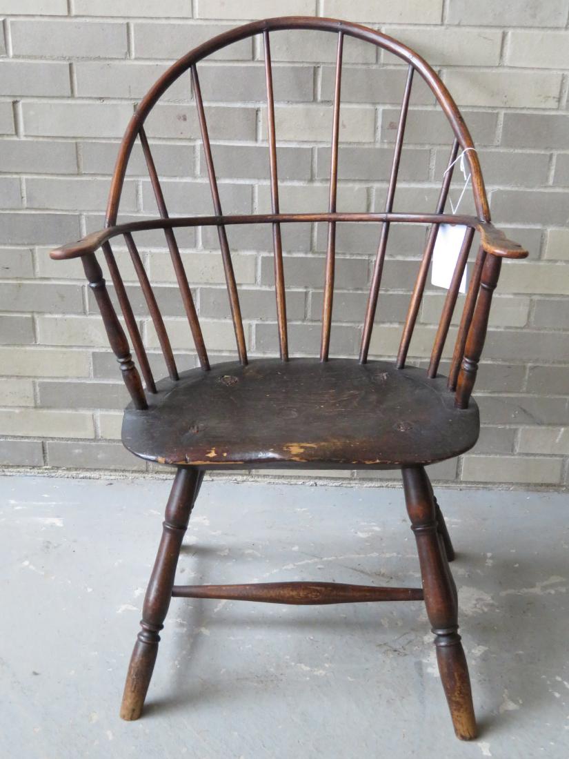 Sack back Windsor in old black stain, possibly: Sack back Windsor in old black stain, possibly original. Splayed legs, saddle seat, medial stretcher. Very old repair to arm, else good condition. 18th century.