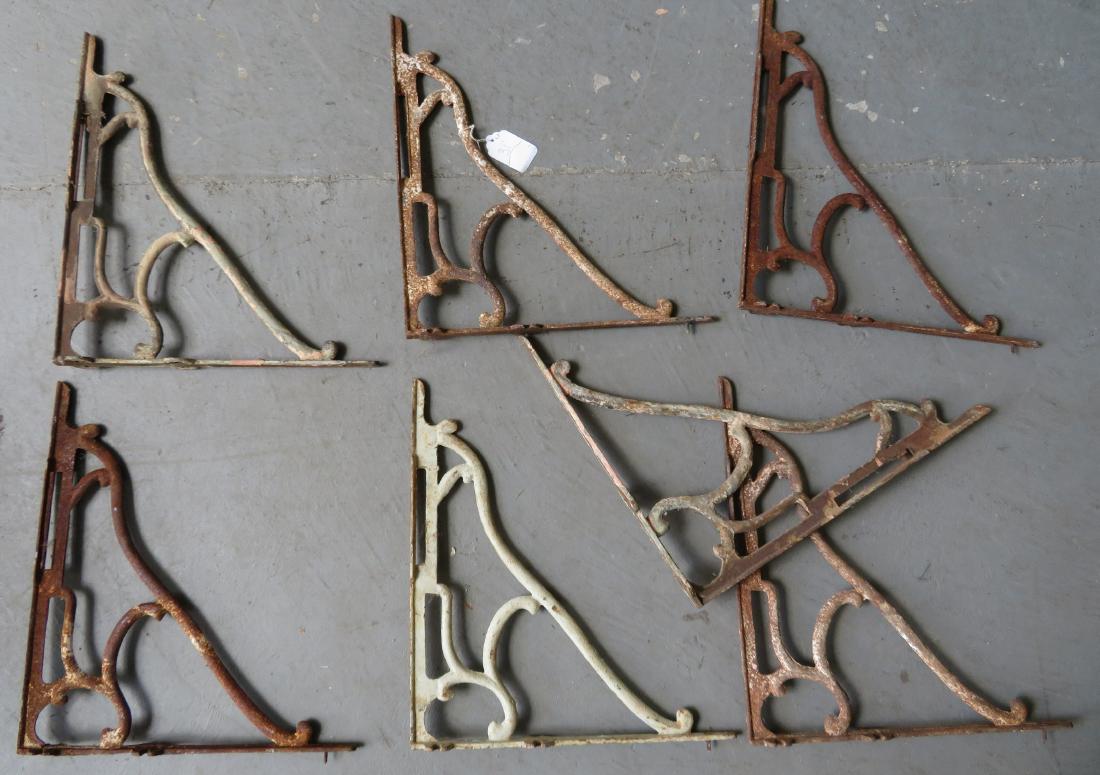 Grouping of 7 matching cast iron wall mounted shelf: Grouping of 7 matching cast iron wall mounted shelf brackets with traces of old white paint, late 19th to early 20th century. 15.75”H x 17.75”D. All with some surface rust, but very good structura