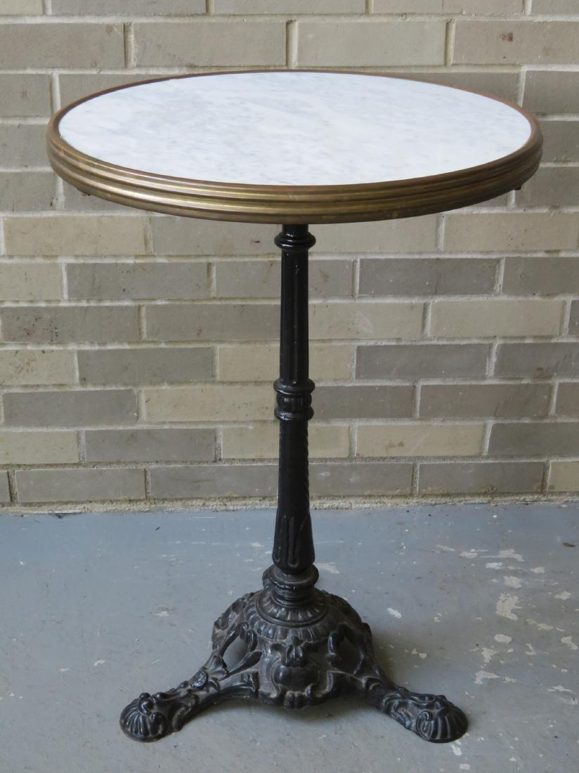 A French cast iron cafe table with ornate pedestals