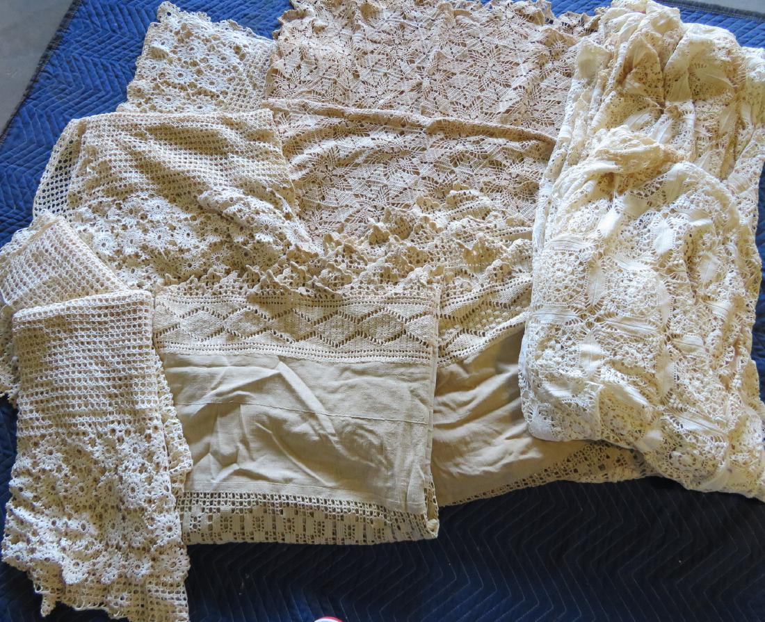 Grouping of crochet bed covers, early 20th century.: Grouping of 5 mostly crochet bed covers, early 20th century and 4 crochet curtain panels. Some with browning (stains), but most in very good condition. The largest decorated with flowers 11' 6" x 6' 6