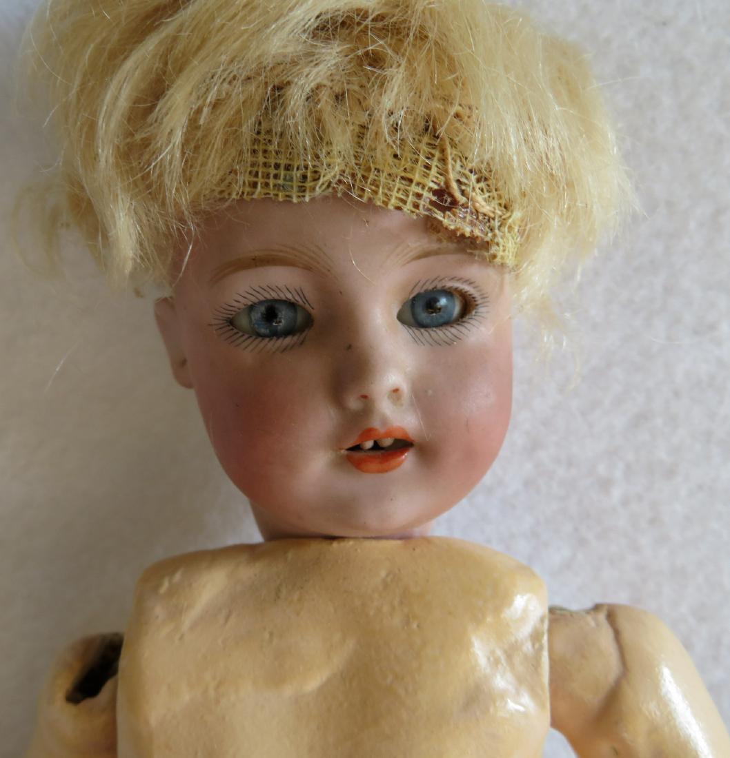 A small German Simon & Halbig #1279 bisque head doll: A small German Simon & Halbig #1279 bisque head doll with sleepy blue eyes, open mouth, and pierced ears - head also signed "Germany / Halbig / S & H / 2"- 10"L - soiled white handmade garments - hair