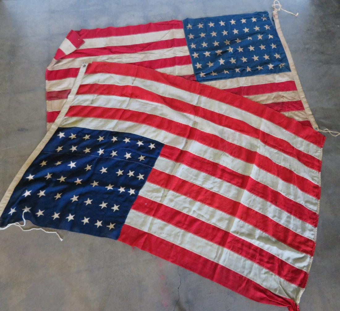 Two American Flags.: Two American flags including a 46 star flag - 69" x 44" - several tiny holes, some stains, small wear/loss in 2 corners, else good condition; 48 star flag - 68" x 43" - tears and losses - fair conditi