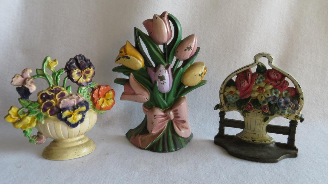 Three cast iron floral door stops in original paint -: Three cast iron floral door stops in original paint - very good condition, ranging in size from 6.5"H to 9.5"H - very colorful.