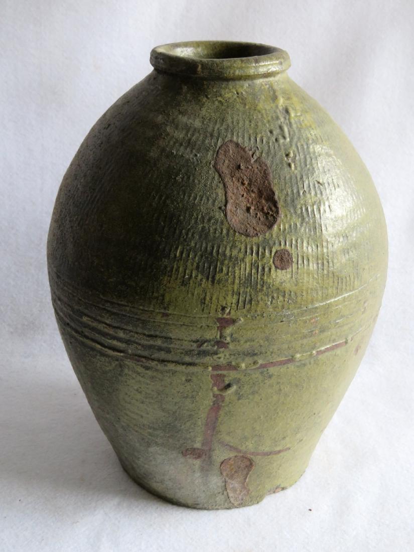 Unusual redware pot with green glaze, the top half: Unusual redware pot with green glaze, the top half section with vertical fluting that meets a grouping of concentric rings near the center. It also has a rolled rim. Various firing imperfections, over