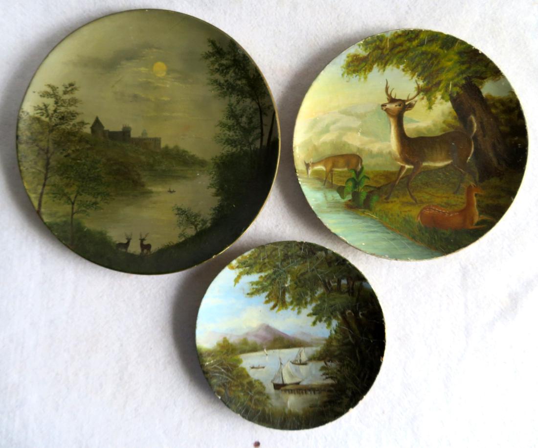 Three 19th century hand painted paper mache plates with: Three 19th century hand painted paper mache plates with landscape themes: 1) Round plate decorated with trees, mountains and lake with sailboats - 8.5"D - some crazing and slight wear around perimeter