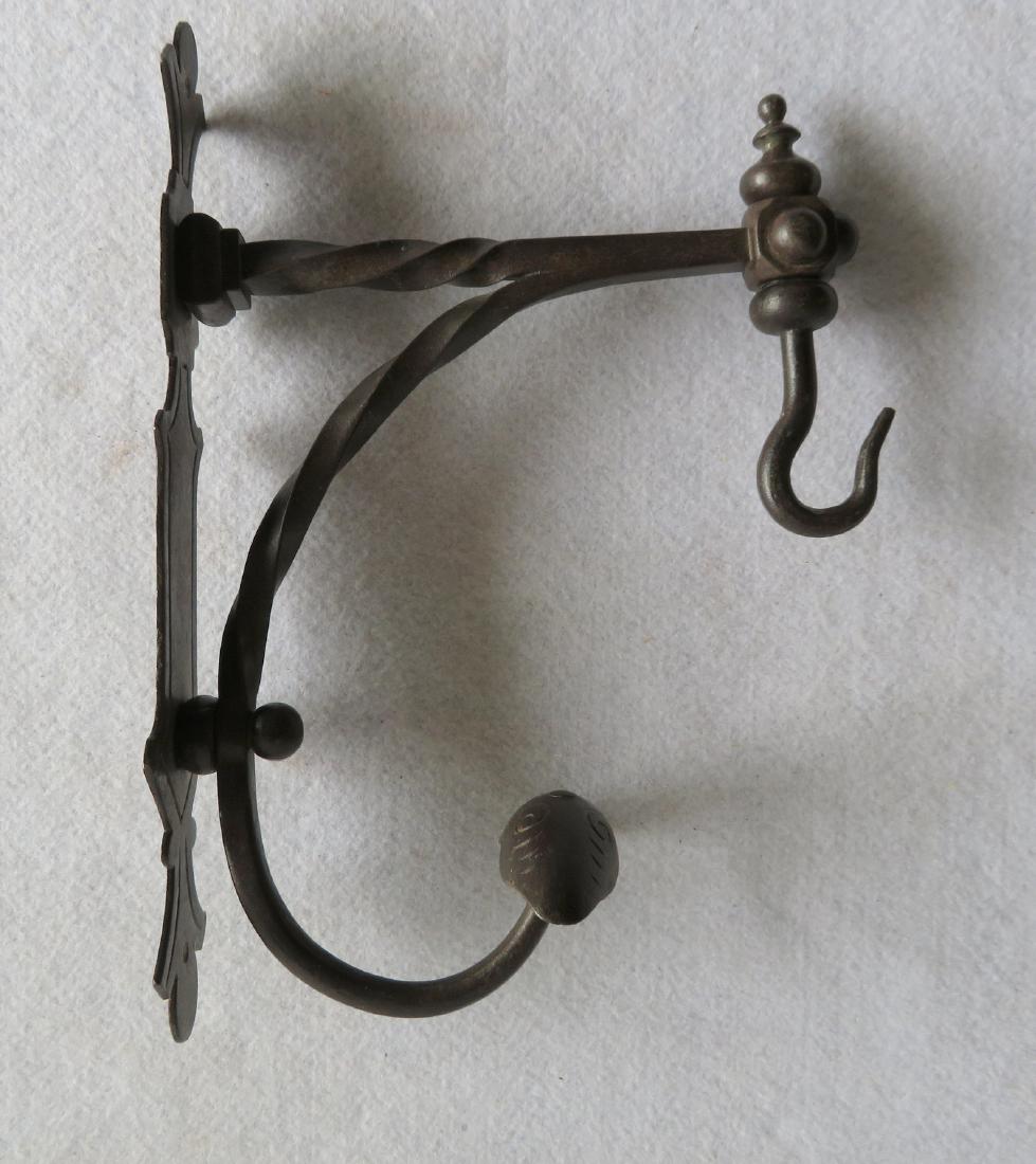Wrought iron wall bracket with hanger attached,: Wrought iron wall bracket with hanger attached, possibly for hanging a lighting device. Probably early 19th century. 11"H x 8"D. Provenance: From the estate of Elliot Steckel, Sharon CT.
