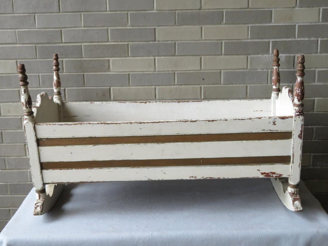 Primitive 18th century cradle with turned posts and: Primitive 18th century cradle with turned posts and shaped crests - newer white paint. Overall good condition. 39"L x 19"W x 23.5"H. Provenance: From a private country collection, Connecticut.