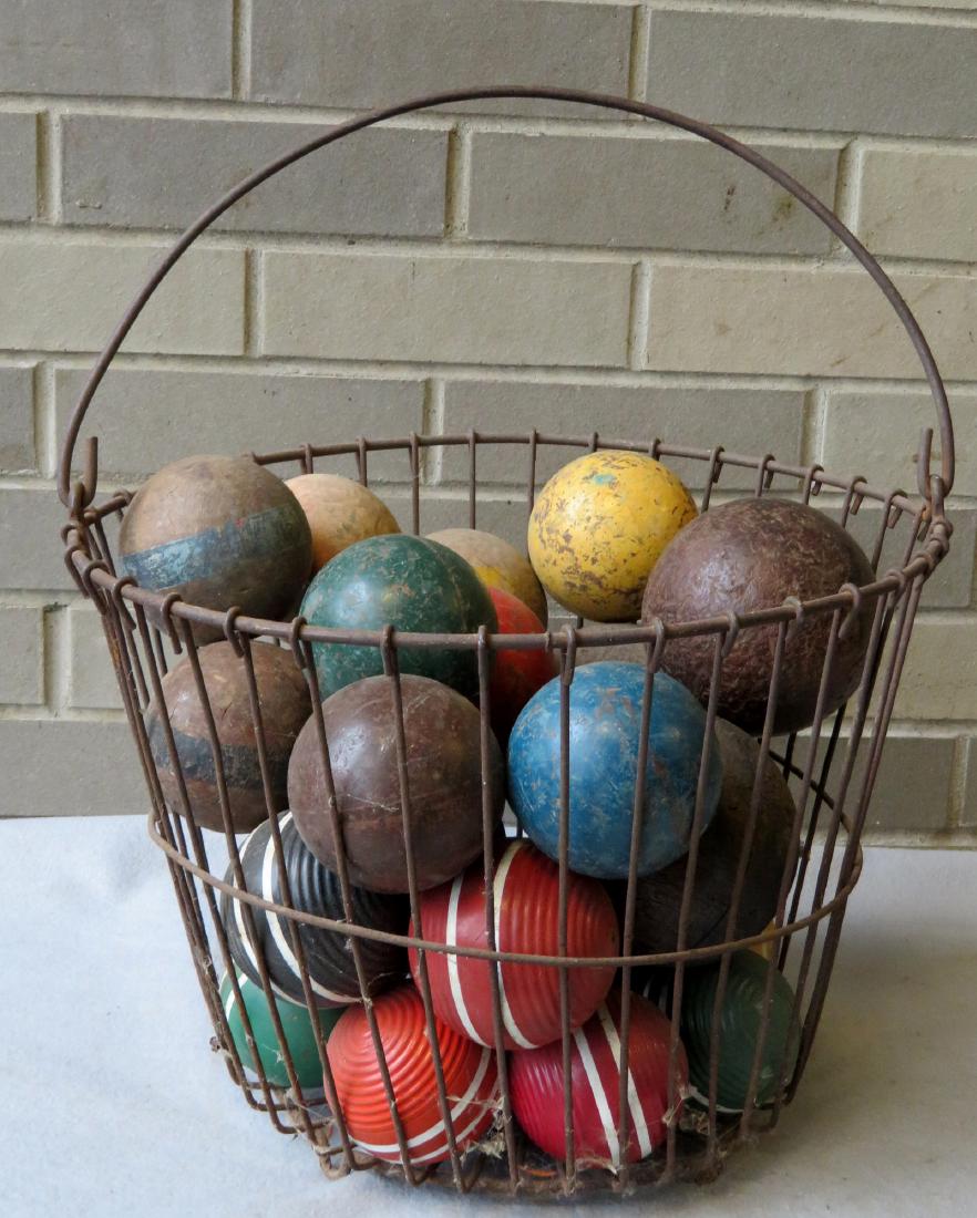 Egg basket with bale handle with 20 lawn & croquet ball: Egg basket with bail handle with 20 lawn & croquet balls, some painted. Late 19th to early 20th century. Most in good condition.