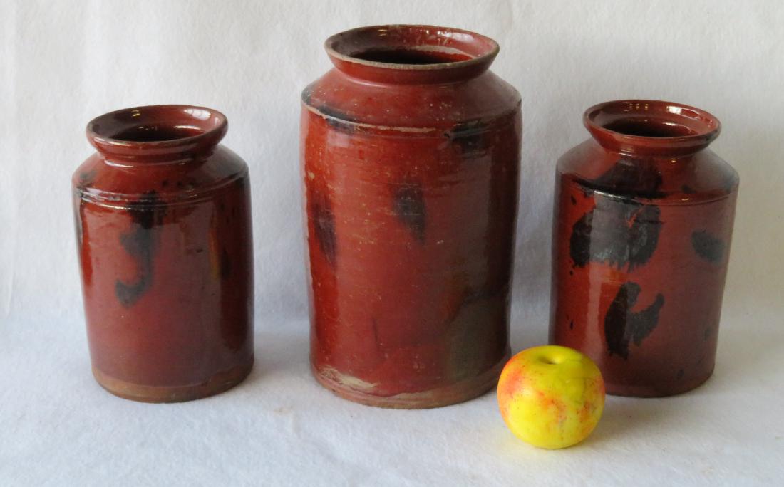 Three redware storage jars with manganese decorations: Three redware storage jars with manganese decorations including 2 at 8.5"H with slight wear/glaze chips on rims, otherwise very good condition - no cracks or repairs; and an 11"H jar with wear/glaze c