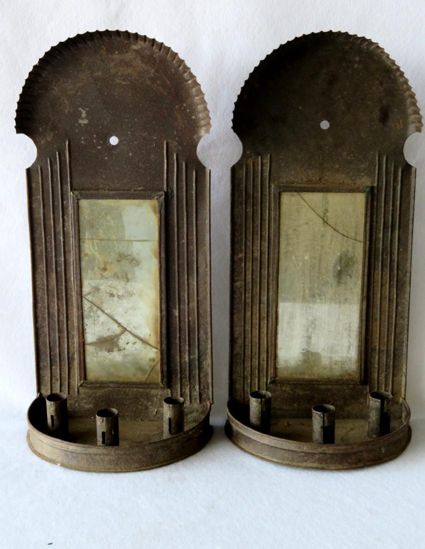 Large pair of tin mirror back wall sconces with crimped: Large pair of tin mirror back wall sconces with crimped dome tops and 3 candle holders on each. Both mirrors appear to be original and are cracked - the bow front on one sconce with rust damage along 