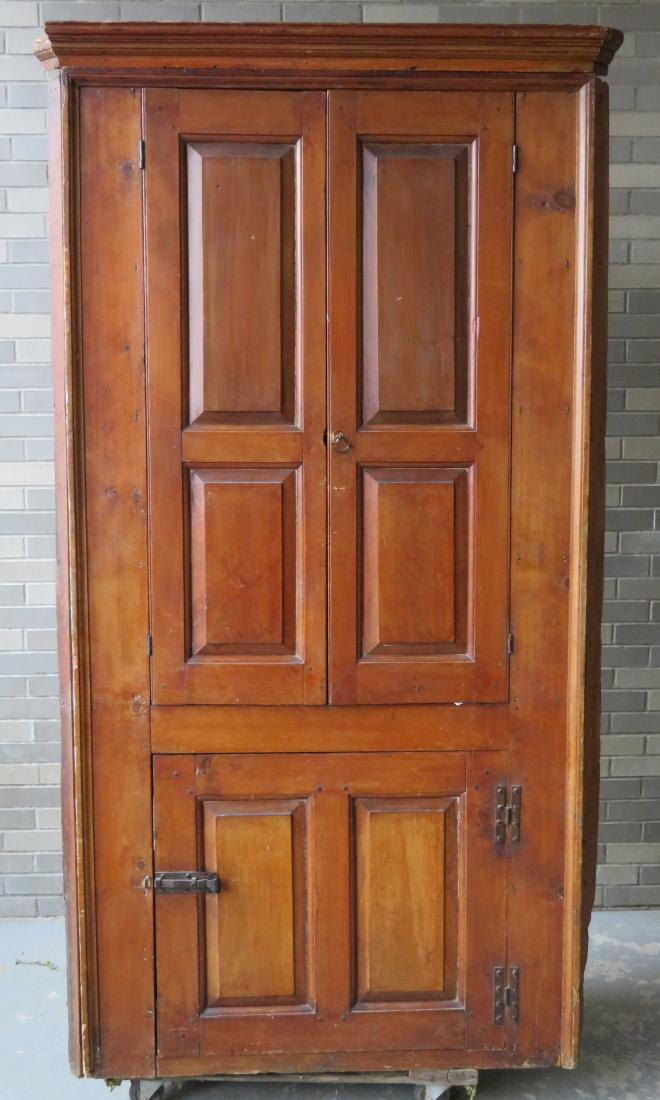 Early barrel back corner cupboard having 2 raised: Early barrel back corner cupboard having 2 raised paneled doors over 1 door with 2 raised panel doors and original cornice. The interior with lollipop plate shelves and its original plaster and lath b