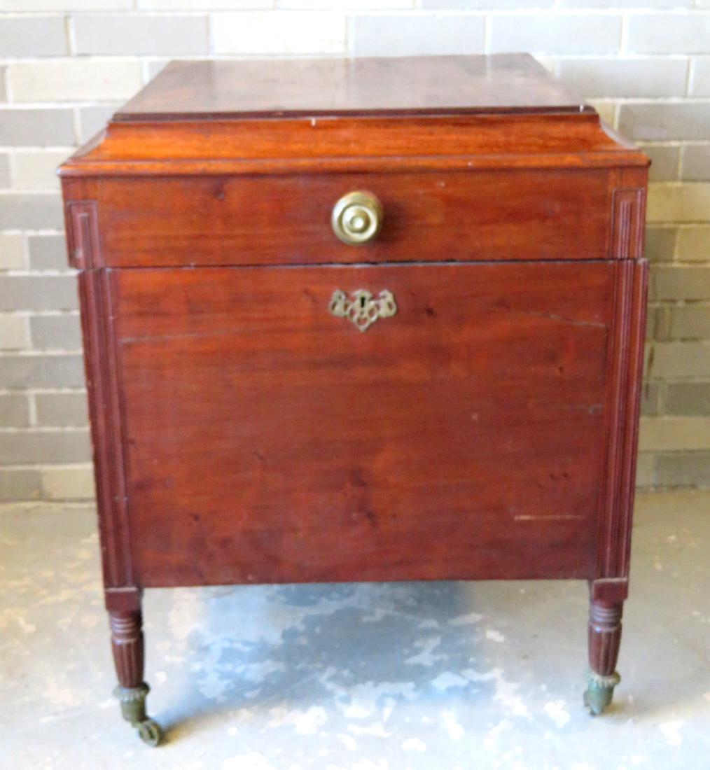 Sheraton mahogany cellarette with fitted interior: Sheraton mahogany cellarette with fitted interior having 16 compartments, and seated on reeded legs with original brass casters - shaped concave border around lid - front with beaded side columns. One