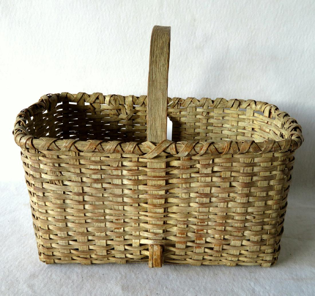 Early splint market basket in old white paint, 19th: Early splint market basket in old white paint, 19th century. Good condition. 20 1/2"L x 13"W x 10"H.