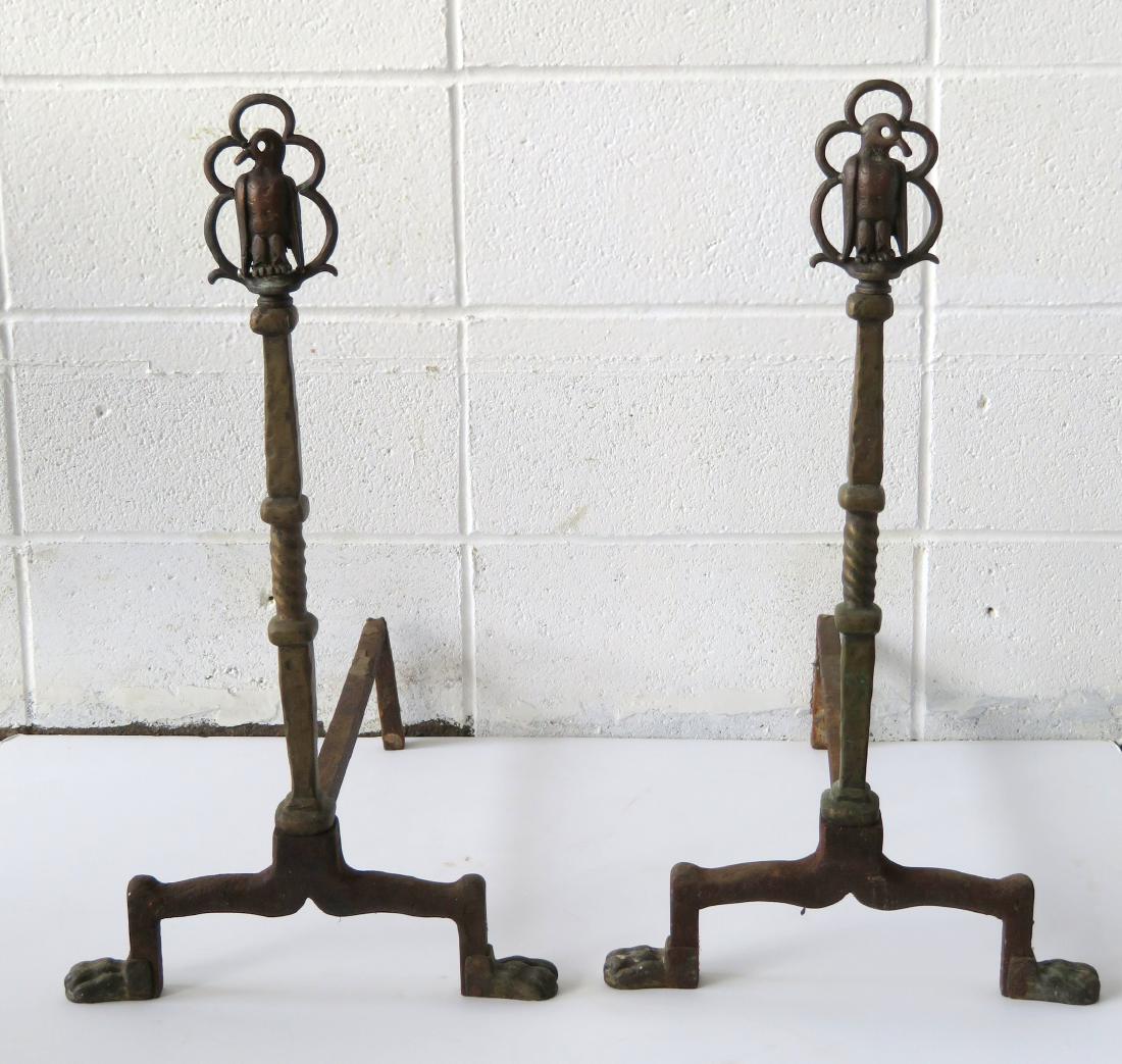 An unusual pair of brass andiron Arts and Crafts: An unusual pair of brass and iron Arts and Crafts andirons having stylized eagle finials over a partial twisted shaft mount on animal paw feet. Early 20th century. Very good condition. 25"H.