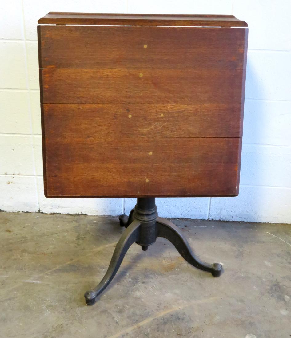 Oak architects drawing table on iron tri-leg base and: Oak architects drawing table on iron tri-leg base and long single drop leaf - late 19th century - very good condition. Size 26"W x 29"D x 37"H.
