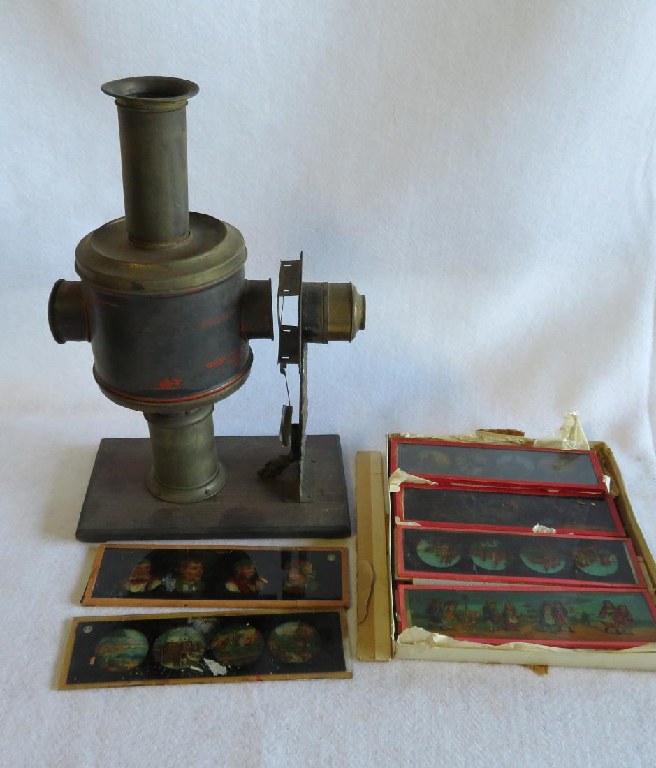 Tin Magic Lantern with slides, traces of original: Tin Magic Lantern with slides, traces of original paint, and retaining its original oil burner. Slides include: 17 @ 8" x 2 3/8" - all in good condition; 2 @ 8 5/8" x 2 3/8" -one with hairline; and 2