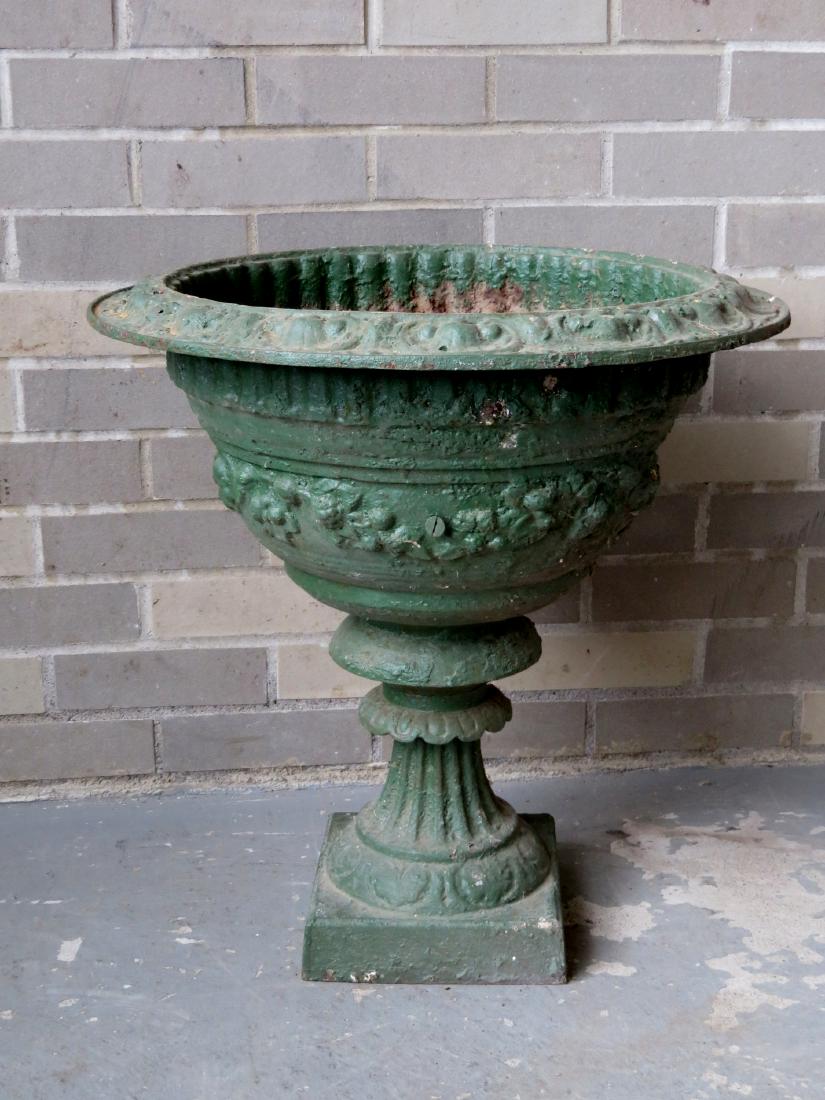 Cast iron garden urn, profusely decorated with flowers: Cast iron garden urn, profusely decorated with flowers on a partial fluted base - one piece construction - 19th century - old green paint - 21.25"H x 20"D - originally had double handles which are now