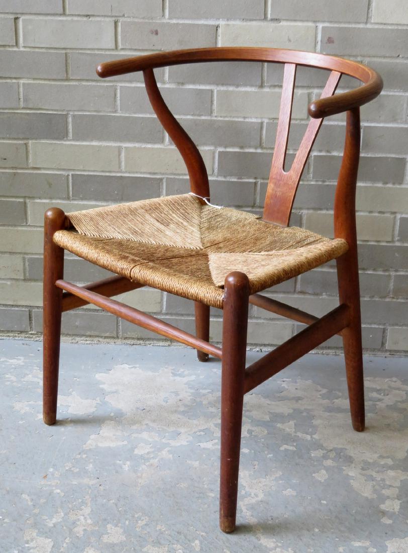 Hans Wegner original wishbone chair with woven seat: Hans Wegner original wishbone chair with woven seat rush-like seat, circa 1940. Size 28.5"H x 21"D x 21"W. Minor use wear, several pieces of the seat cords are broken, else very good condition.