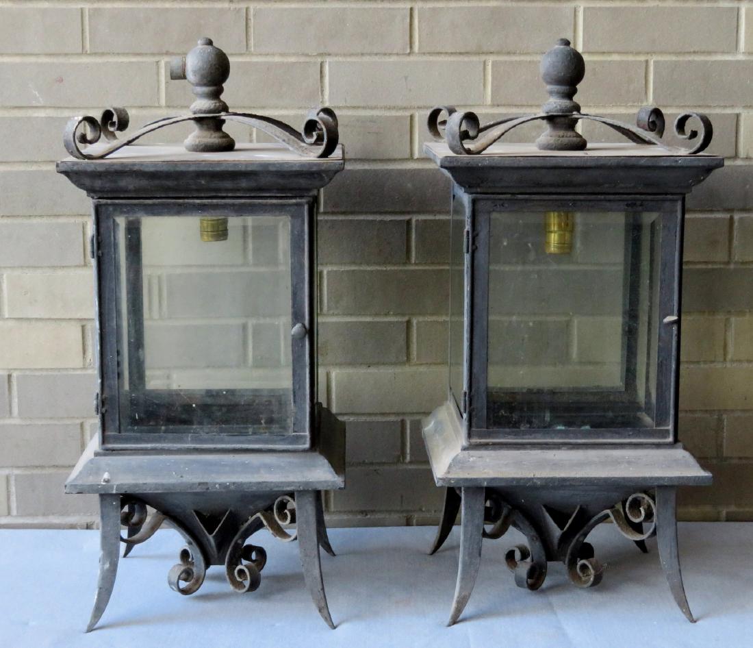 Two early iron post lanterns with beveled glass sides: Two early iron post lanterns with beveled glass sides on a fancy base in old black paint. Both were originally gas lanterns, but were electrified later in life and the top reversed with the bottom to