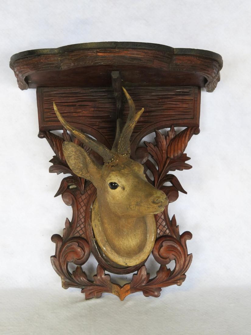 Wall mounted Victorian self with deer head below black: Wall mounted Victorian self with deer head below black walnut surface. The deer head with real deer horns applied to head. The head with glass eyes appears to be hand carved wood in original paint, bu