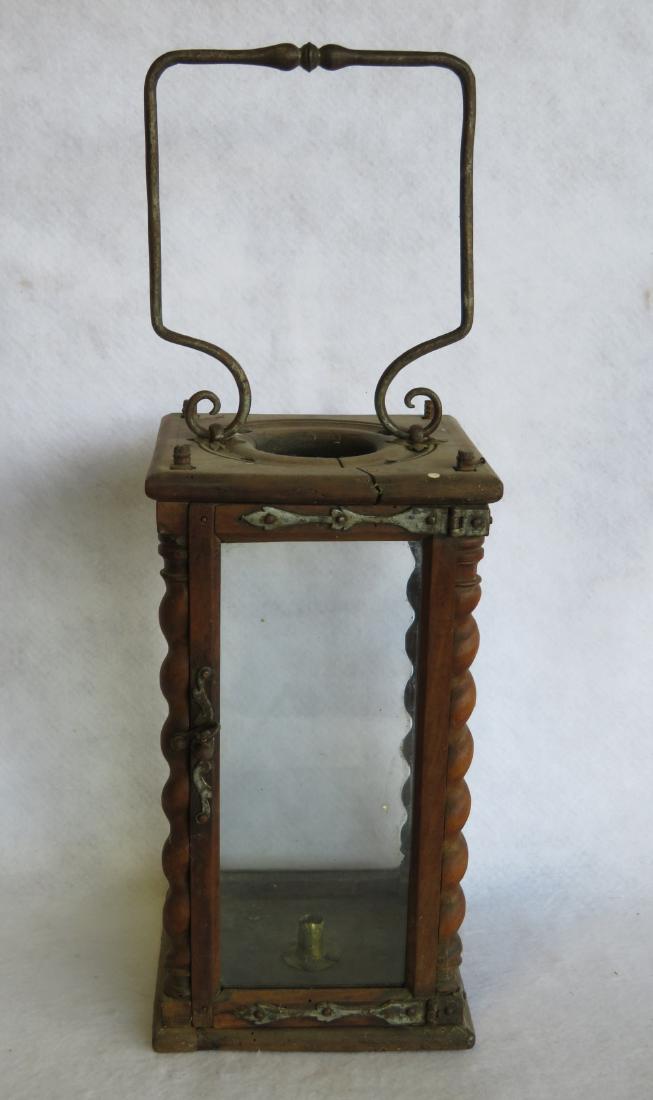 An unusual wooden candle lantern with glass sides,: An unusual wooden candle lantern with glass sides, turned wooden columns in all 4 corners, circular vented top and a shaped hand made iron bail handle. The door with shaped hand forged iron strap hing