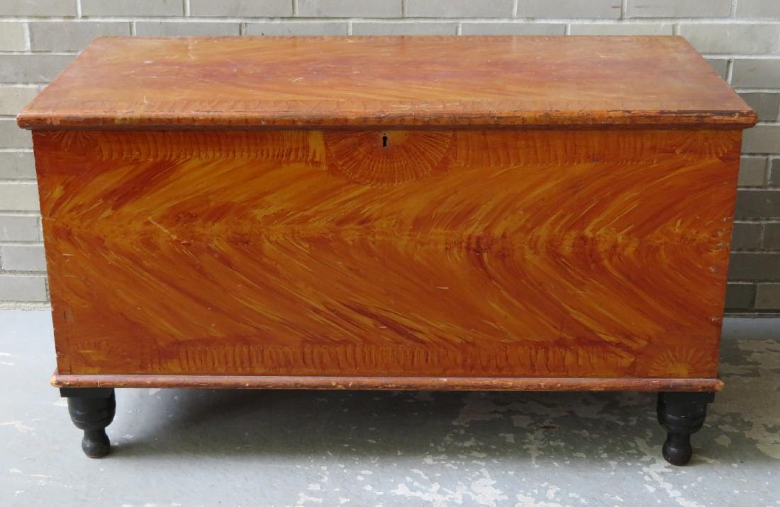 Grain painted blanket box in original flaming: Grain painted blanket box in original flaming reddish-brown colors and having a dark green border around rim and matching color on turned feet - note the sponge decorated banding around the perimeter