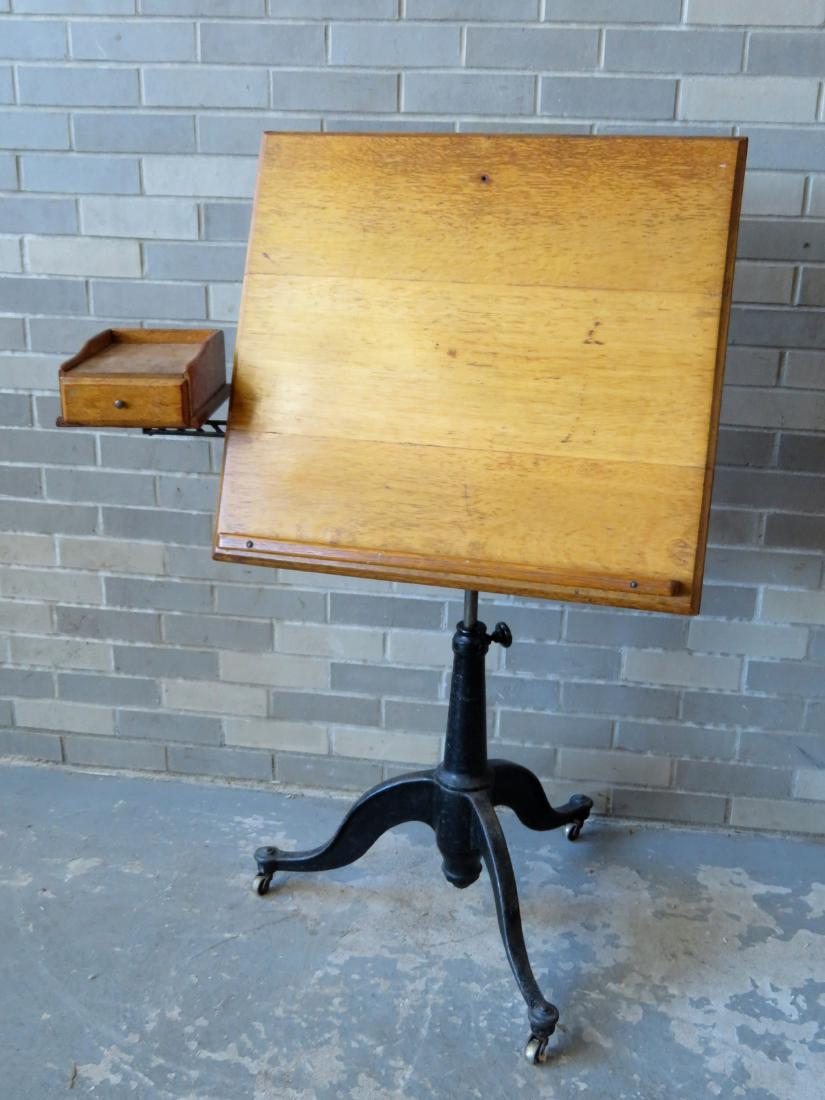 A very fine architect's or artist's oak drawing table: A very fine architect's or artist's oak drawing table mounted on an iron base with an adjustable writing/drawing surface. The turned iron base on Queen Ann style legs, has a moveable iron arm that sup