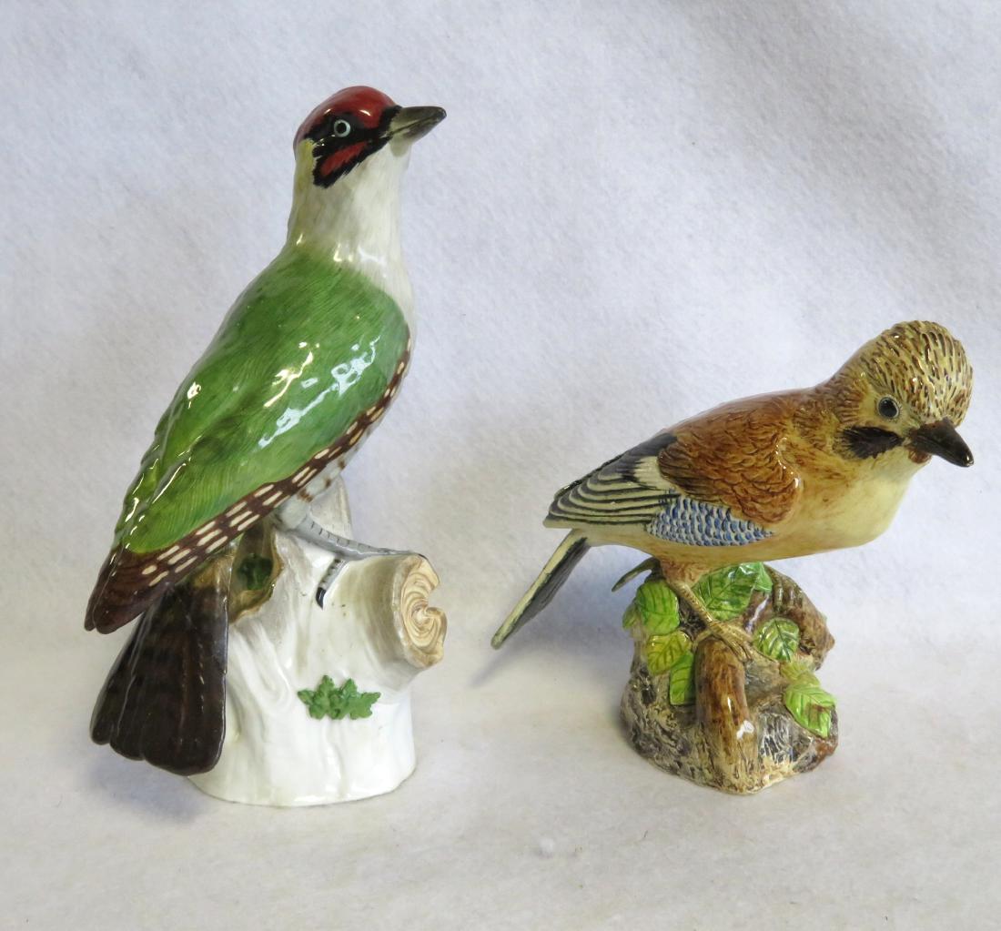 Two beautiful high quality hand painted porcelain bird: Two beautiful high quality hand painted porcelain bird sculptures. The larger, a Green Woodpecker, perched on stump and signed Dresden with blue mark, 9 1/2"H x 5"W - repair to tail feather, small fir