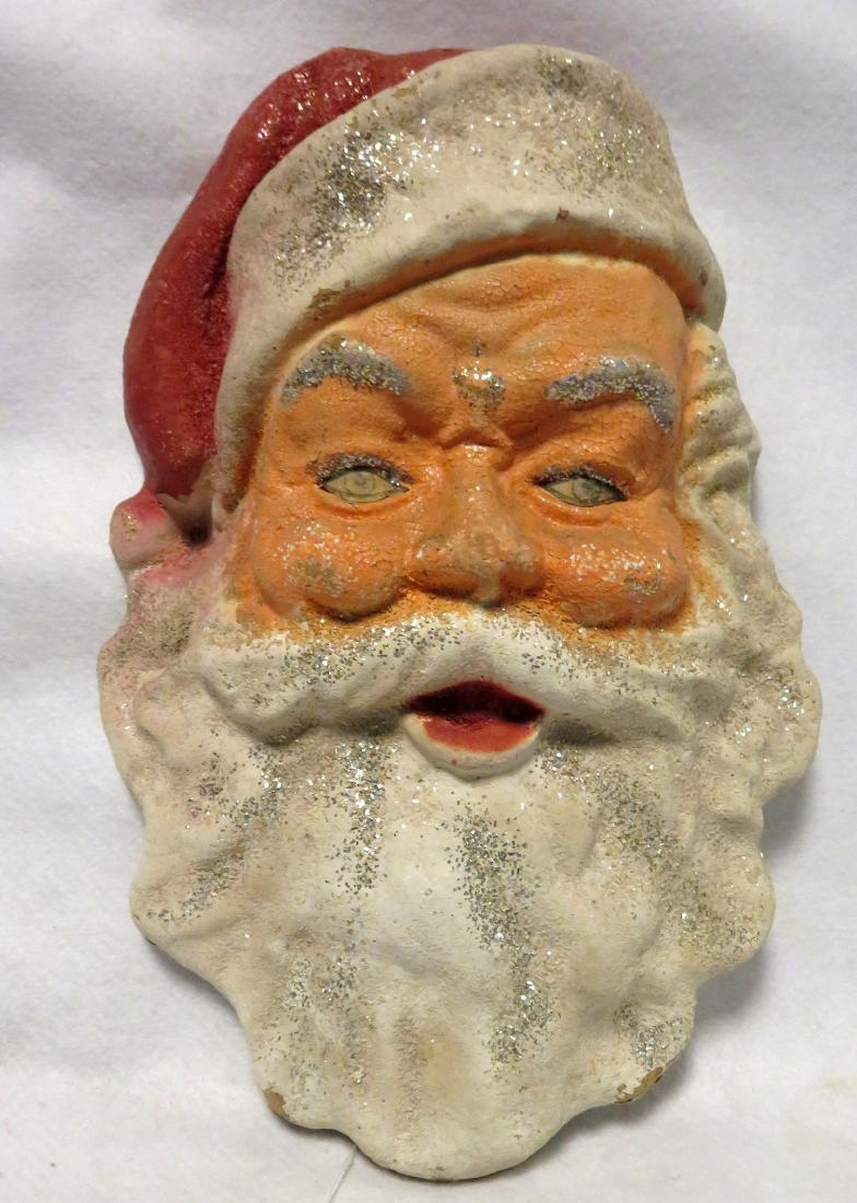 A vintage paper mache Santa Clause face wall hanging