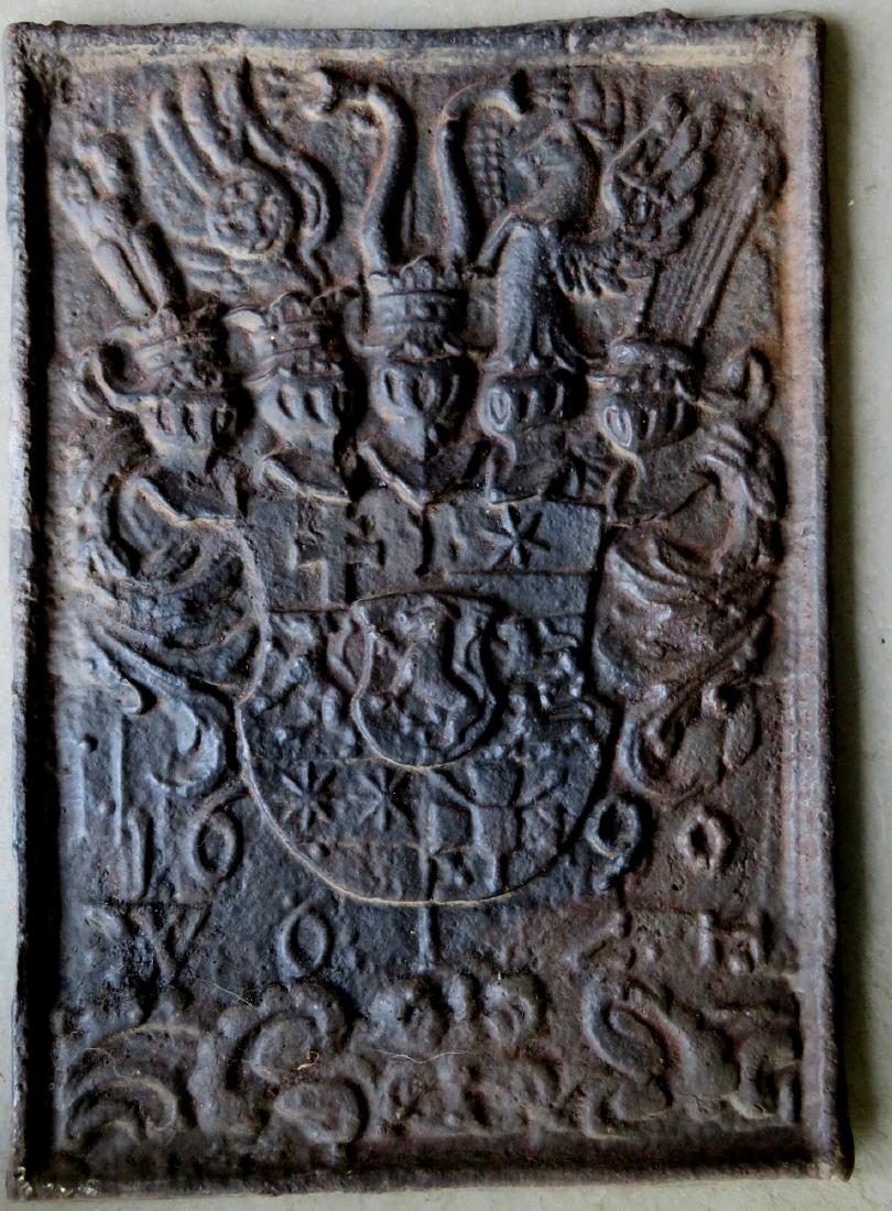 Cast iron fireback dated 1600 or 1690, decorated with a: Cast iron fireback dated 1600 or 1690, decorated with a coat of arms below helmets - it appears to be signed WOLZH at base . 21"H x 15"W. Provenance: From a private collection of Country Americana and