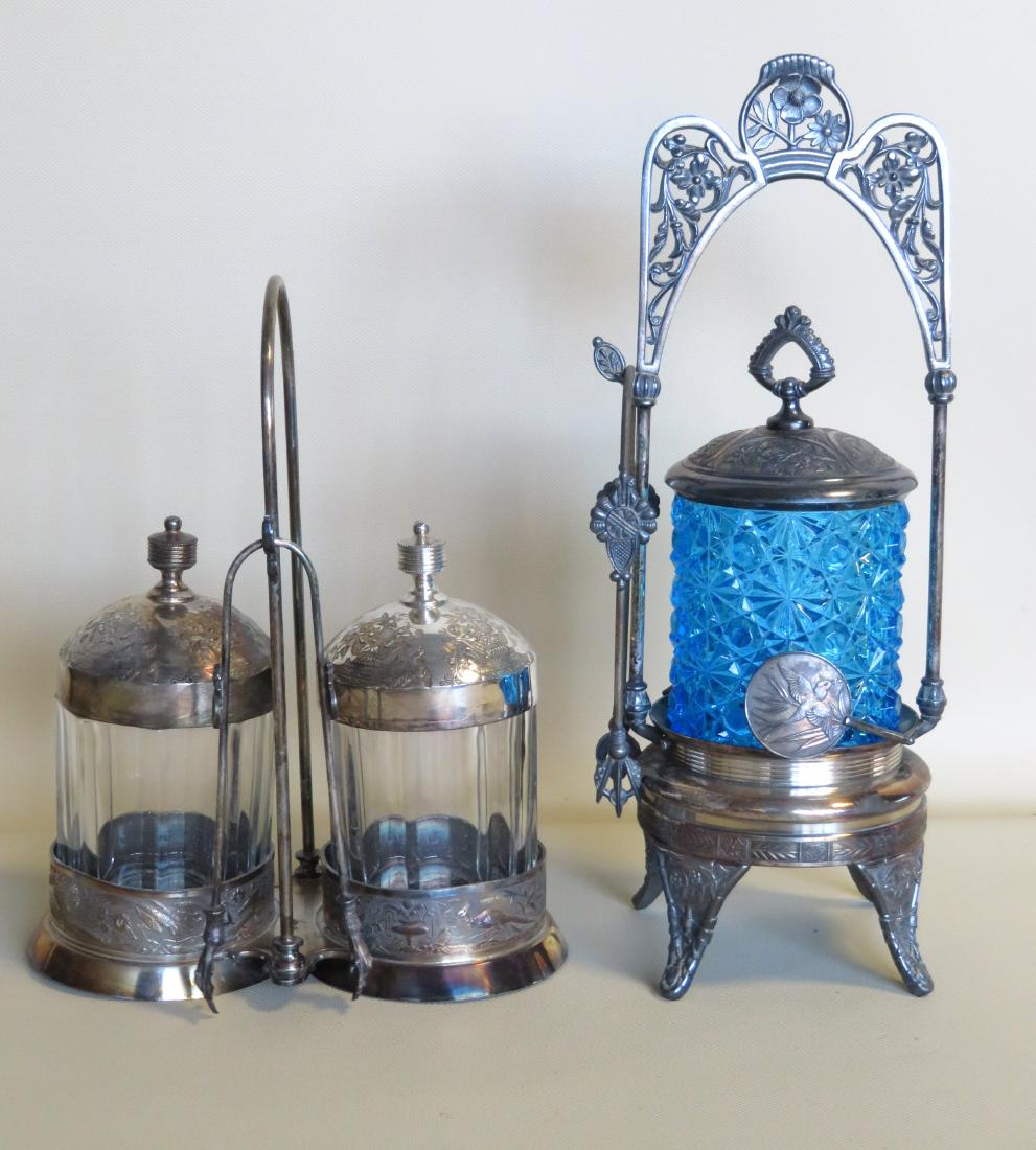 Two Victorian pickle casters with silver plated: Two Victorian pickle casters with silver plated holders, one blue pressed glass with a holder having applied fans with etched birds on each - very good condition, the other a double in colorless glass
