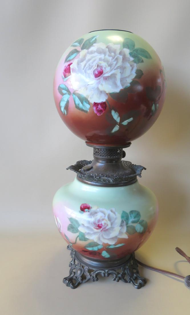 A Victorian "Gone With The Wind" oil lamp with matching: A Victorian "Gone With The Wind" oil lamp with matching hand painted shade decorated with roses, electrified, otherwise very good condition. 22 1/2"H x 10"W. Circa 1880.