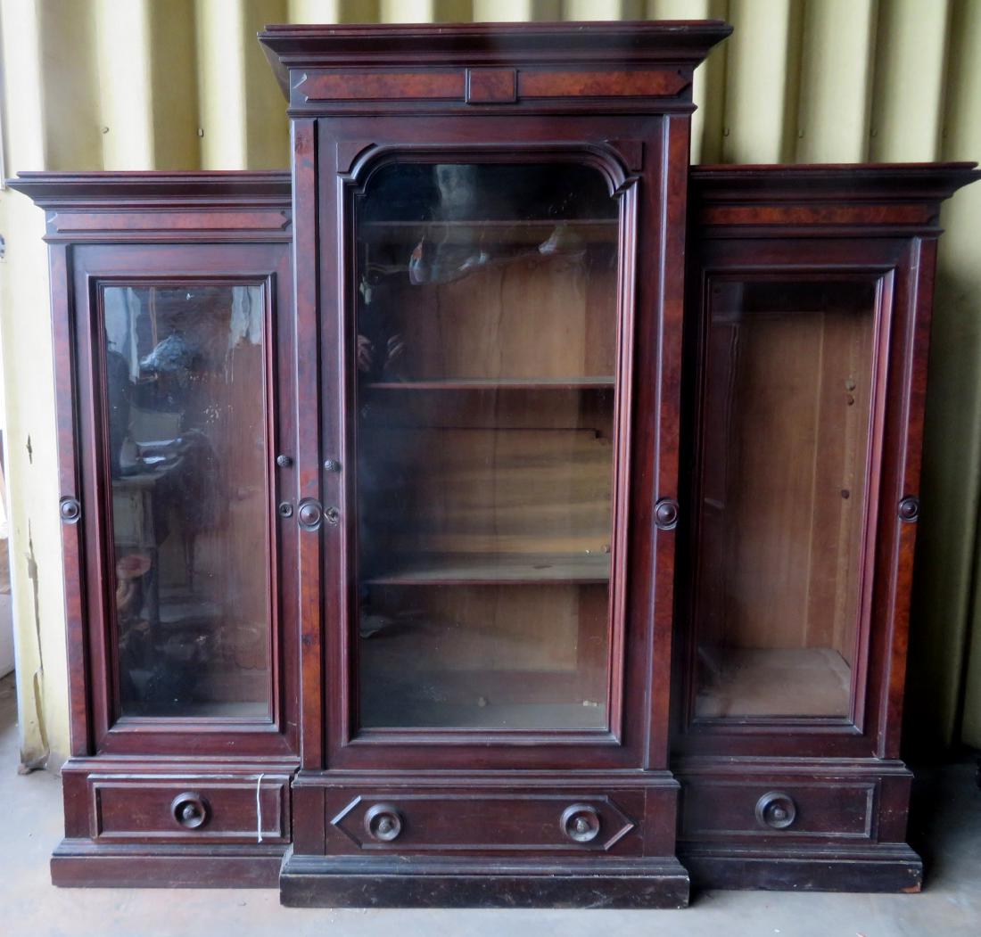 Renaissance Revival 3 section black walnut bookcase,: Renaissance Revival 3 section black walnut bookcase, having a central bookcase flanked by 2 step-back bookcase sections, each over a lower drawer - each section also with burl walnut panels. Minor sur