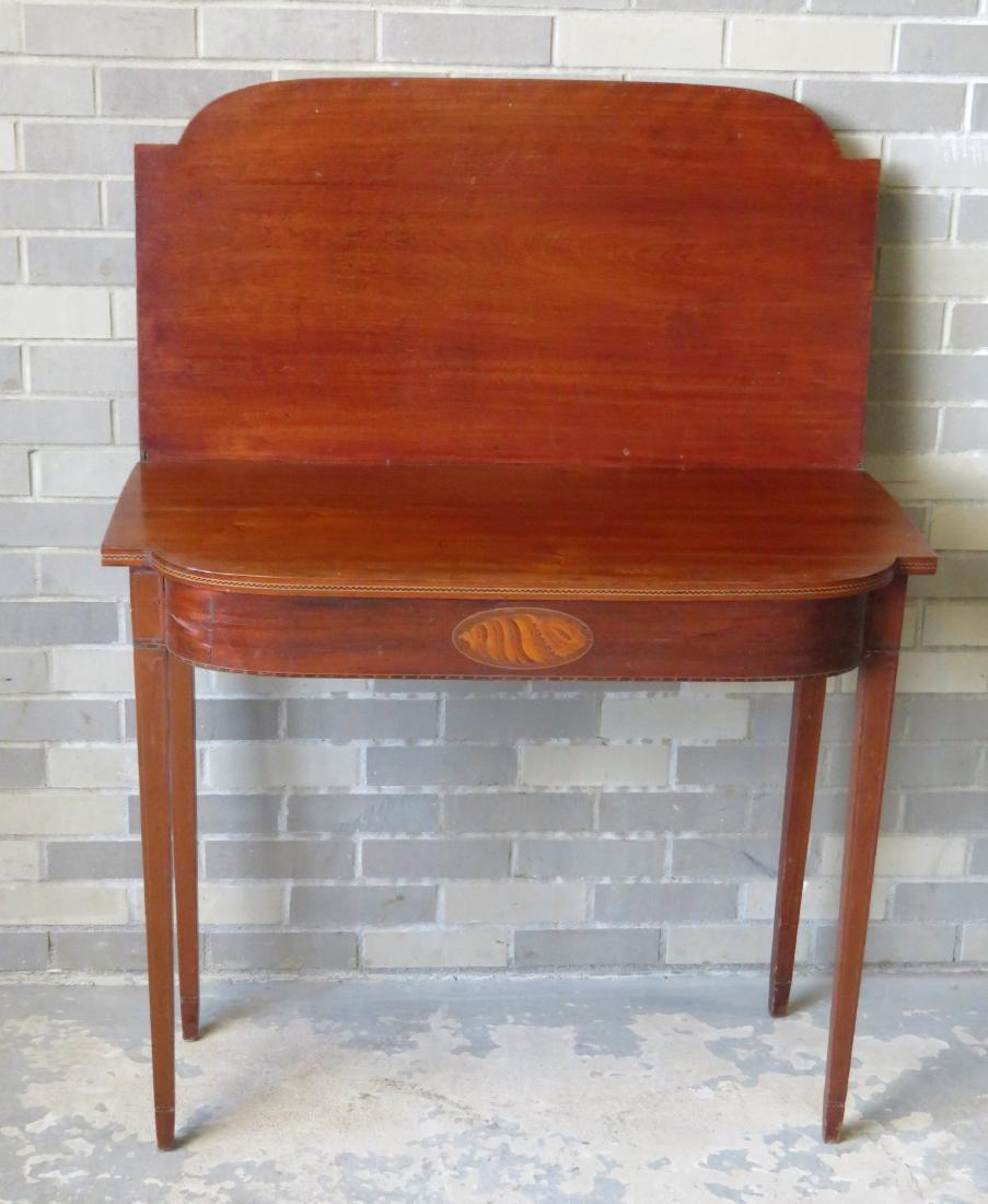 Hepplewhite birch game table with checkered inlay: Hepplewhite birch game table with checkered inlay across the front of top boards, over an inlaid sconce across the front apron. The lower game table board is very warped pushing up the top board so it