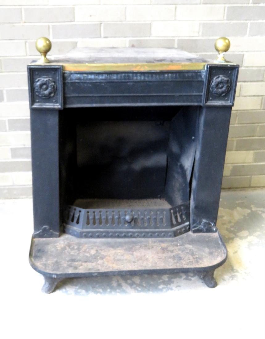 Barstow Stove Co., Franklin stove with brass ball: Barstow Stove Co., Franklin stove with brass ball finials above a framed brass floral plaque (painted black) on each side of the upper apron, constructed of cast iron, tin and brass - old, but not ori