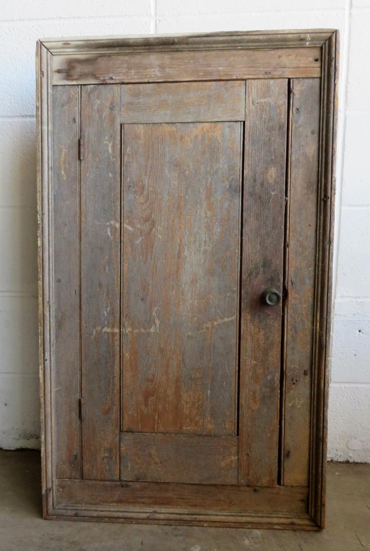 A primitive 19th century build in single door wall: A primitive 19th century build in single door wall cupboard with picture frame molding and traces of original blue/gray paint - 21 1/2"W x 36 3/4"H x 8 1/4"D. Never had backboards, and overall good co